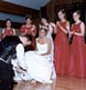groom removing the garter with bridesmaids looking on