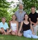 A nuclear family group at home, subset of extended family portrait.