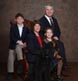 A nice formal family portrait with their dog and family heirloom chair.